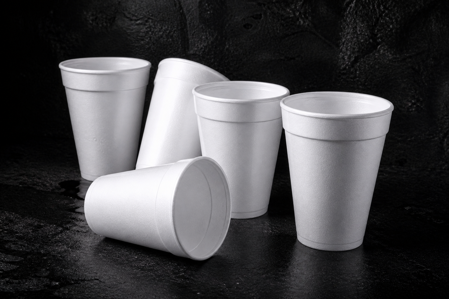 Disposable foam cups collapsing beside a crushed cup